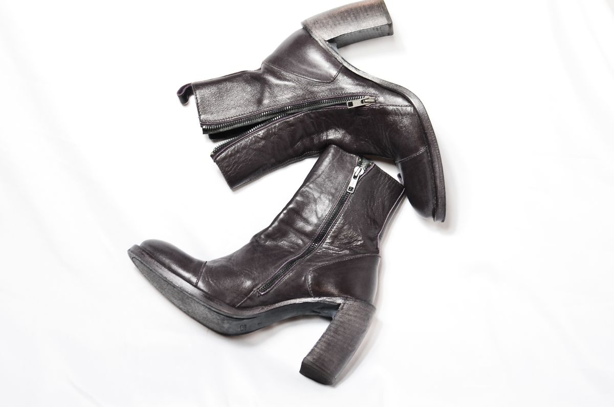Dark brown leather heeled boots on a white surface.